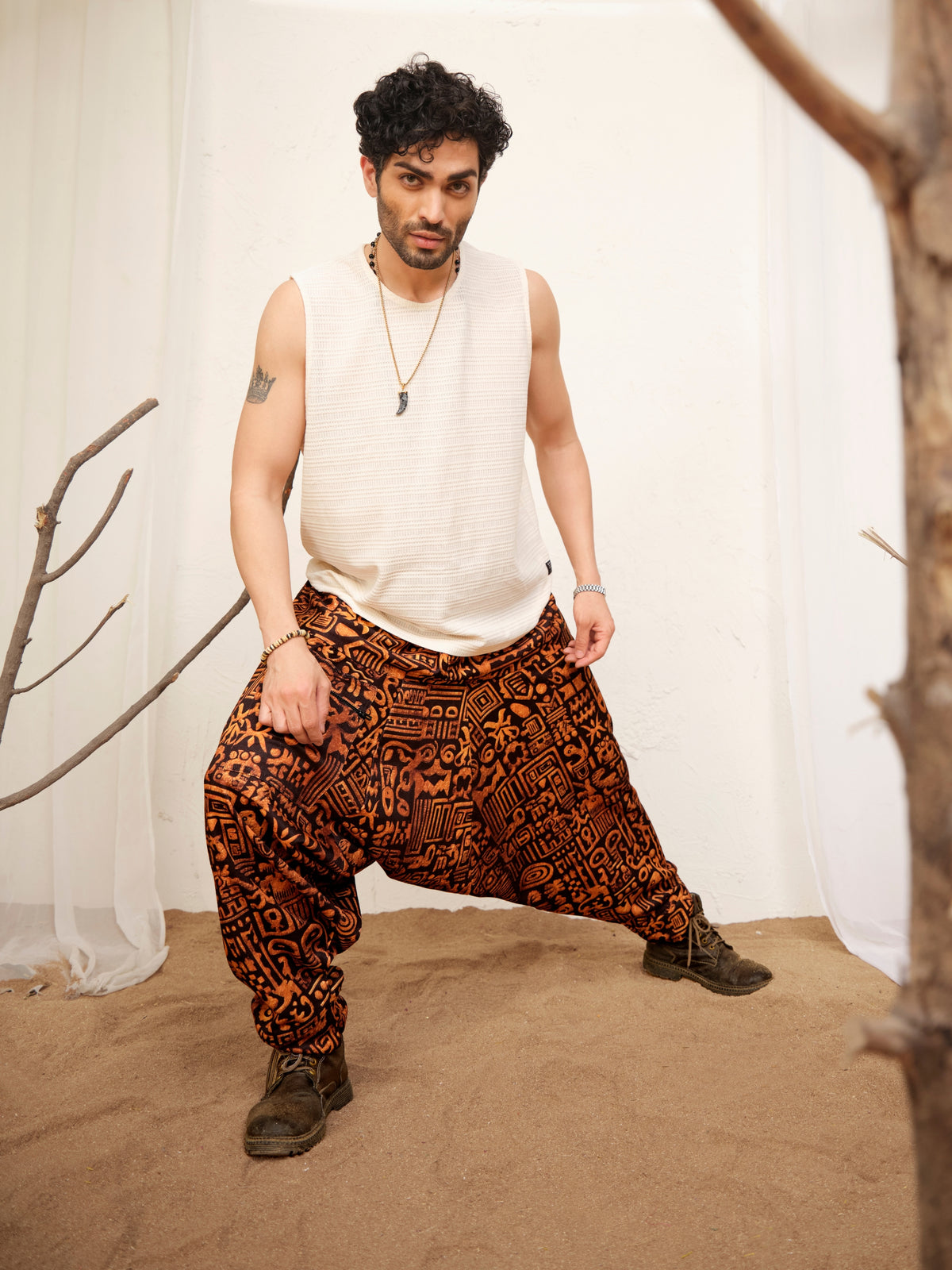 Men's black printed harem pants with all-over rust-orange symbol pattern